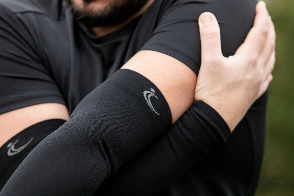 FITLEGs black arm compression sleeve, worn by athlete on both arms.