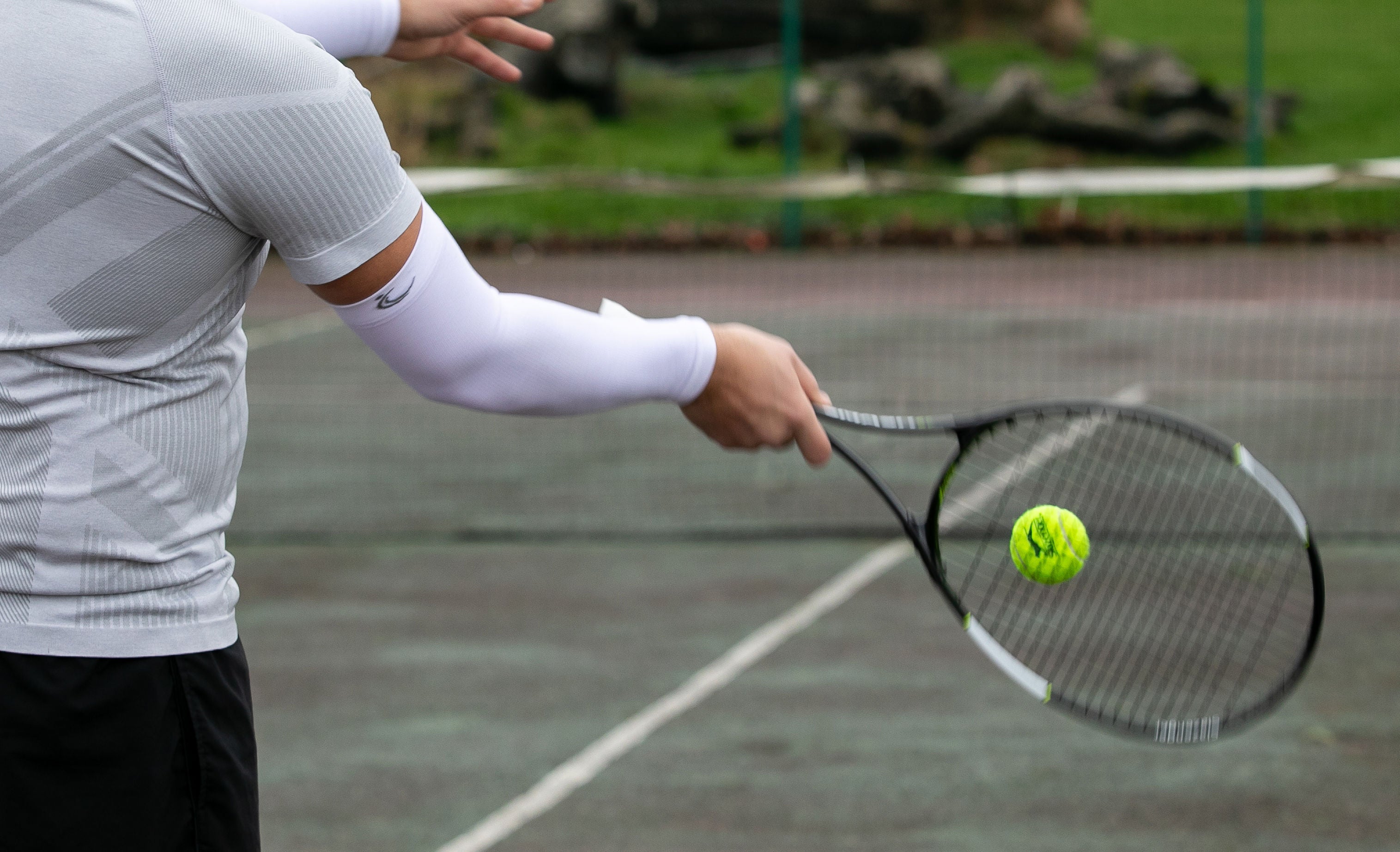 FITLEGs white arm compression sleeve - worn by tennis player