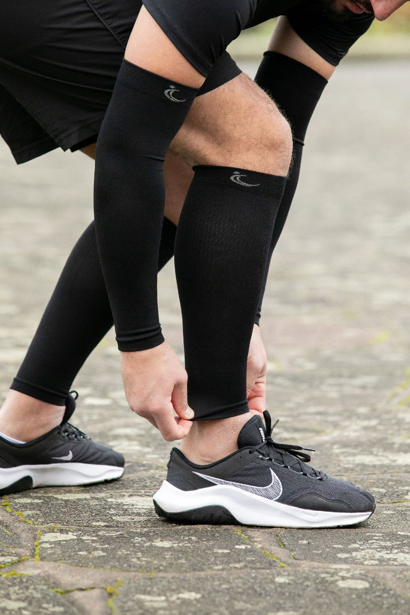 FITLEGs sports calf compression sleeves worn by athlete with black arm compression sleeve