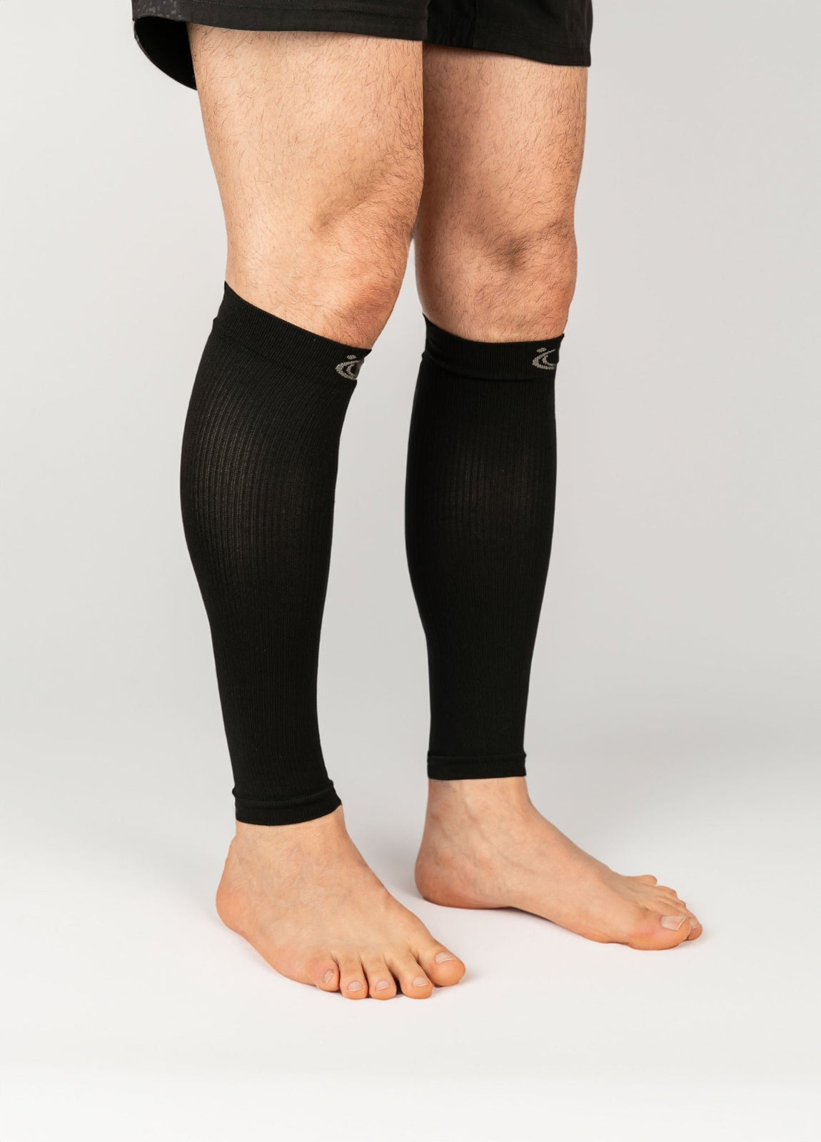 FITLEGs calf compression sleeves in black. Worn on both legs by model.
