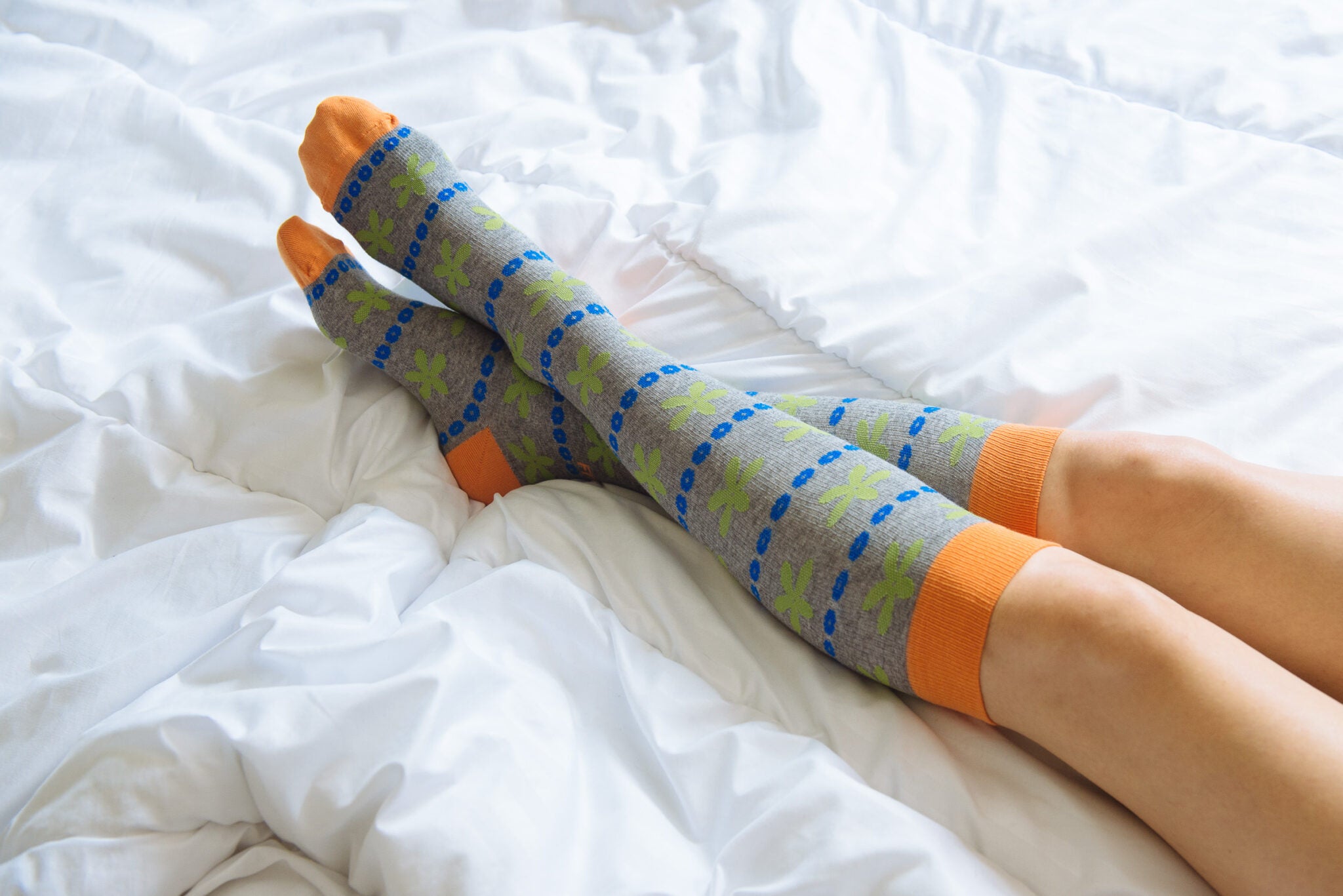 fitlegs everyday life compression socks - knee high - grey and orange - worn on bed